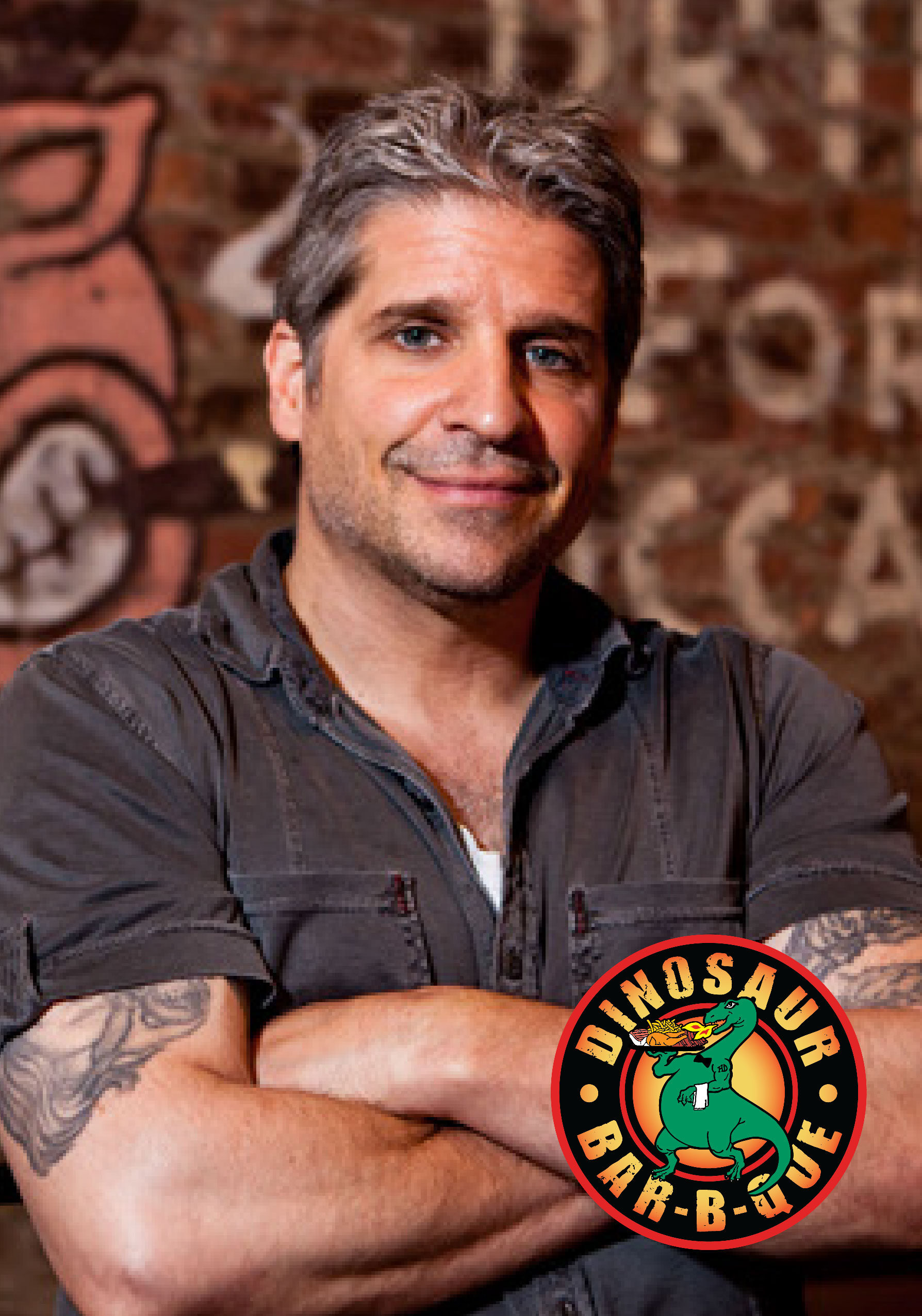 John Stage at Dinosaur Bar-B-Que standing in front of a brick wall with his arms crossed